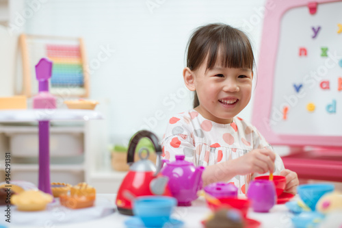 toddler girl prerend play preparing tea party at home
