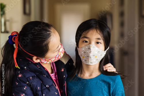 Older sister reassures little girl about wearing cloth mask