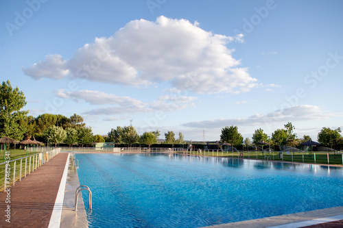 Fototapeta Naklejka Na Ścianę i Meble -  Sunny swimming pool with blue water