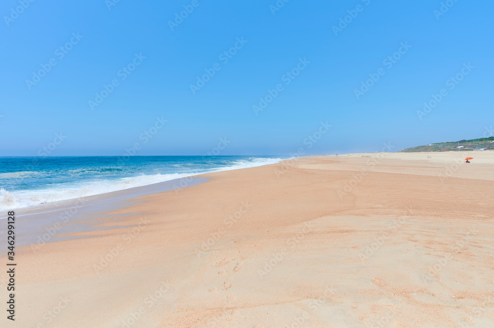 Long sandy beach on a sunny day at Nazaré norte beach