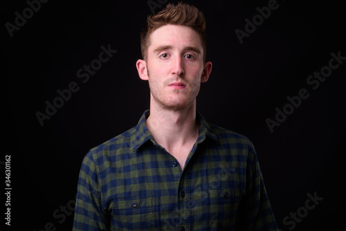 Face of young handsome hipster man looking at camera