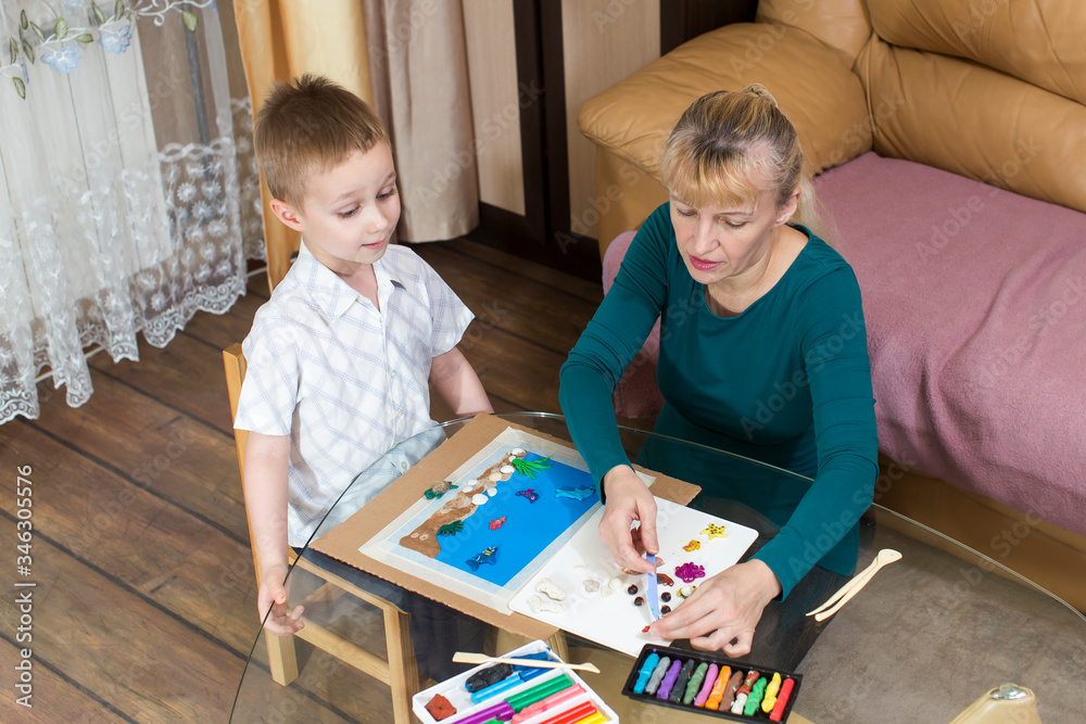 in quarantine, grandson and grandmother engaged in modeling from plasticine in quarantine, grandson and grandmother engaged in modeling from plasticine