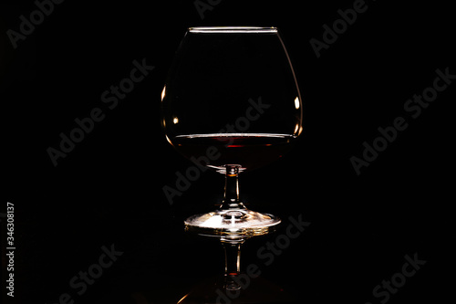 Glass with cognac on a black background photo