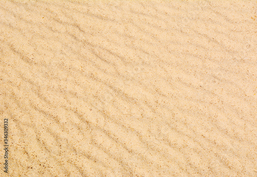 Sand texture with waves. Yellow sand. Background from fine sand.