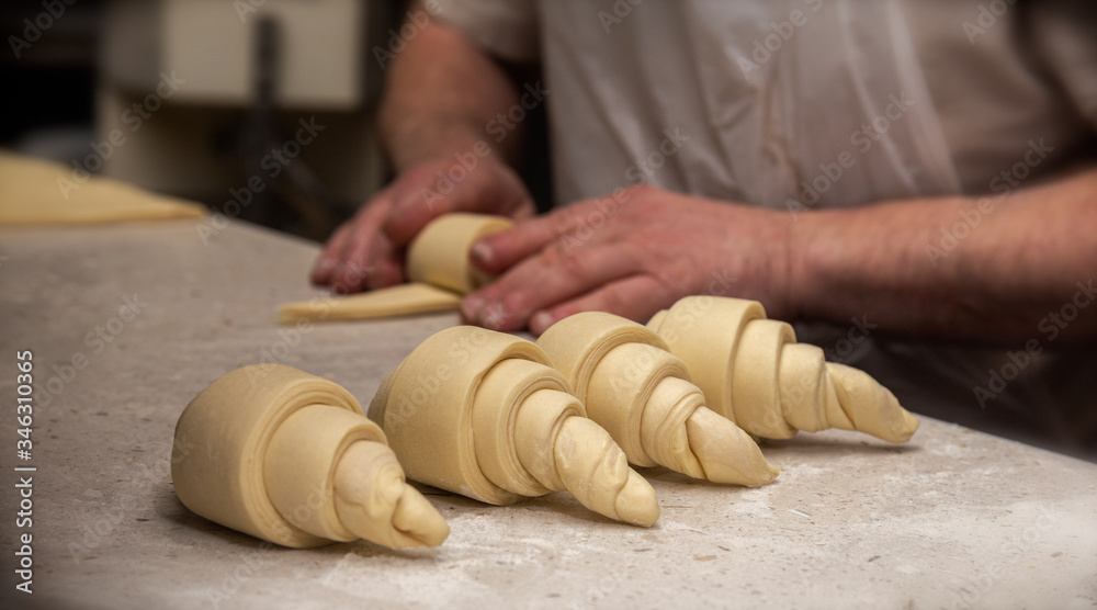 Αυτοκόλλητο French baker rolling croissants on a granite bench top with flour on it