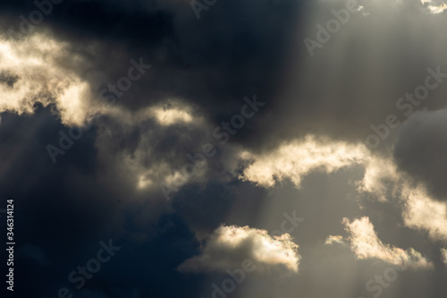 Sun rays through black storm clouds
