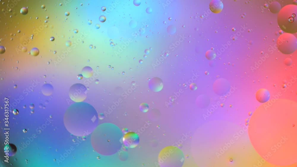 Top view movement of bubbles in the liquid. Oil surface multicolored background. Fantastic structure of colorful bubbles. Colorful artistic image of oil drop floating on the water Top view movement of bubbles in the liquid. Oil surface multicolored background. Fantastic structure of colorful bubbles. Colorful artistic image of oil drop floating on the water