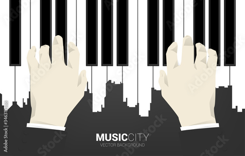 Hand with piano key shaped the the big city outline silhouette. Background concept for classic song event and music festival