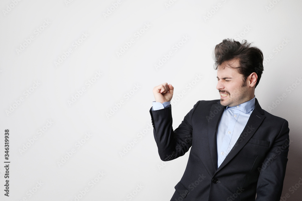Shot of young businessman wearing suit and blue shirt with success gesture. Free space for text. Shot of young businessman wearing suit and blue shirt with success gesture. Free space for text.