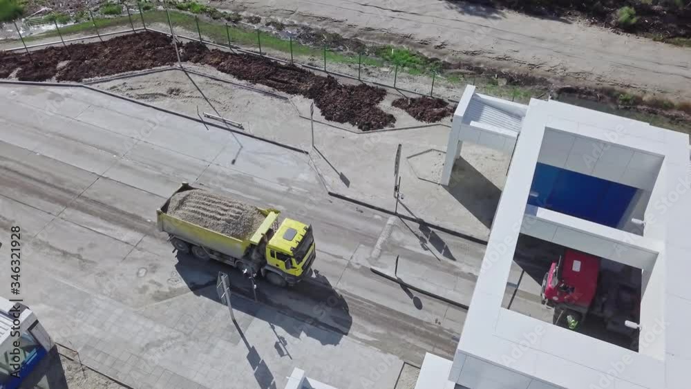 a yellow truck loaded with sand, pulls up to a checkpoint. Freight transportation. Construction work at a closed facility. Logistic work. a yellow truck loaded with sand, pulls up to a checkpoint. Freight transportation. Construction work at a closed facility. Logistic work.
