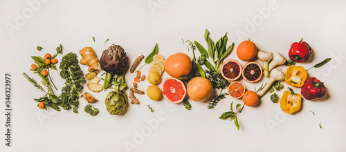 Variety of immunity boosting foods. Flat-lay of ginger, turmeric, kale, artichoke, citrus fruit, herbs, garlic, pepper over white background, top view. Healthy, vegan virus defeating ingredients photo