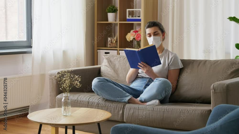 health, safety and pandemic concept - sick young woman in protective medical mask reading book at home health, safety and pandemic concept - sick young woman in protective medical mask reading book at home