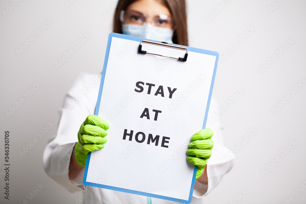Doctor holding form urging to stay at home during quarantine Doctor holding form urging to stay at home during quarantine