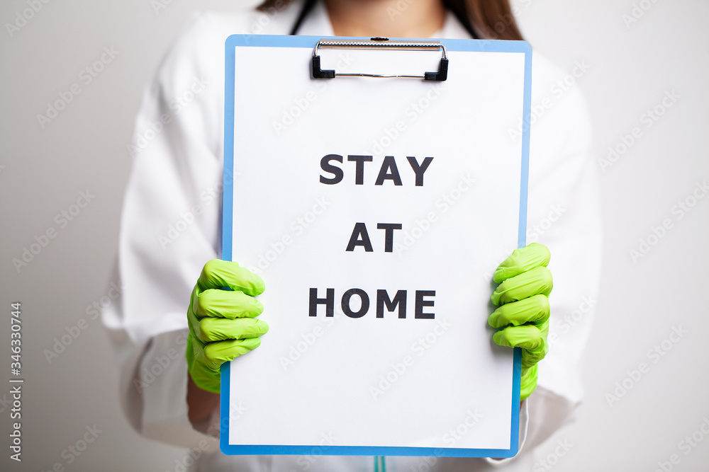 Doctor holding form urging to stay at home during quarantine Doctor holding form urging to stay at home during quarantine