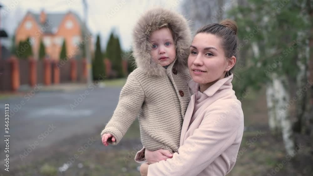 Portrait of smiling mom with little daughter on a cool autumn evening, close up Portrait of smiling mom with little daughter on a cool autumn evening, close up
