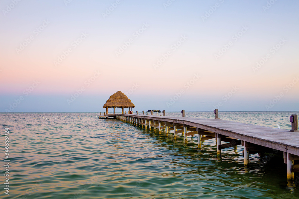 Empty pier at tropical sea coast at the sunset