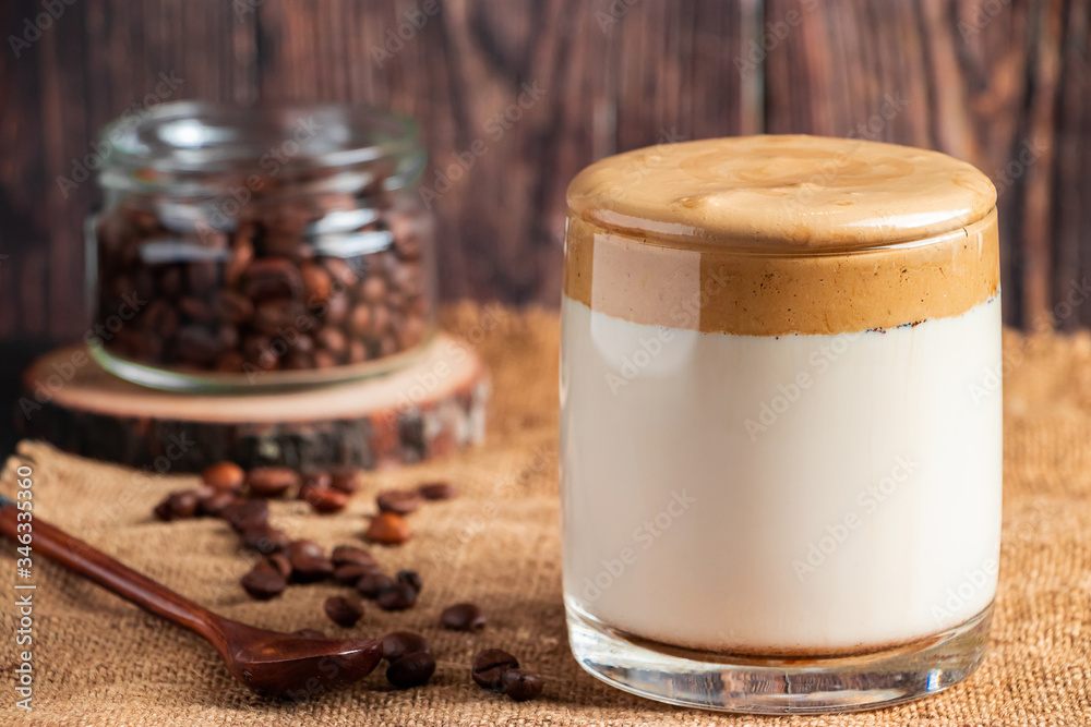 Dalgona coffee on a wooden background. A glass of trendy drink made from milk and whipped foam. Rustic style Dalgona coffee on a wooden background. A glass of trendy drink made from milk and whipped foam. Rustic style