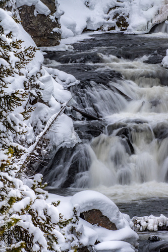 Cascades and waterfalls surrounded by pine trees and snow in Yellowstone