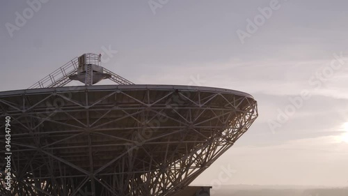 Aerial rising above a a sizeable astronomical satellite dish. Megastructure amidst remote countryside photo