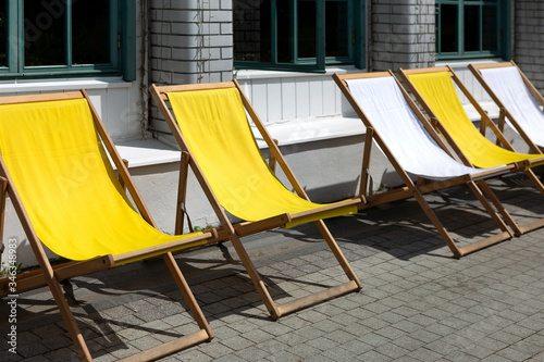 Empty deck chairs or chairs near cafe or restaurant. Outdoor summer area for recreation near summer cafe. Lack of vacationers  quarantine   pandemic and business crash  collapse.