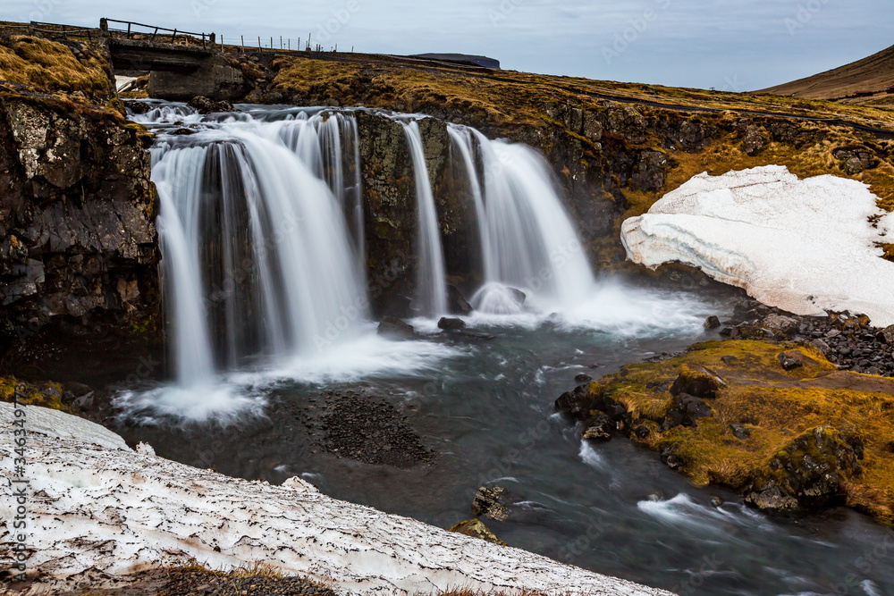 Kirkjufellsfoss waterfalls surrounded by melting snow in February