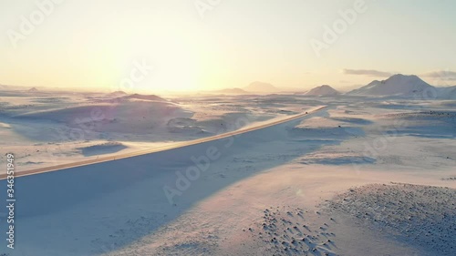 Aerial of a Road with Car Driving in Snow Desert with Mountains at Sunset Sunrise - Ulysse Tassin Winter Iceland Drone 17/38 photo