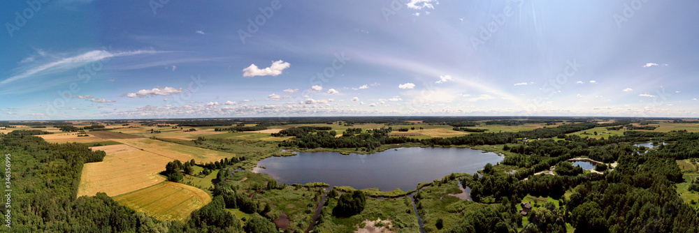 Summer end farmland panorama with lake, aerial