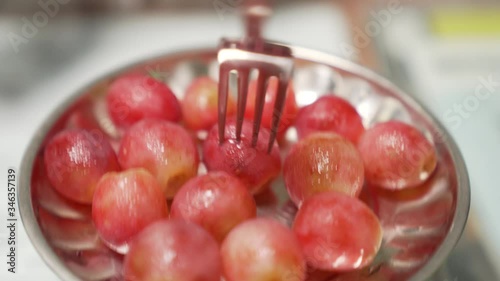 Picking up a grape from a plate from a fork POV subject isolated with deep background blur photo