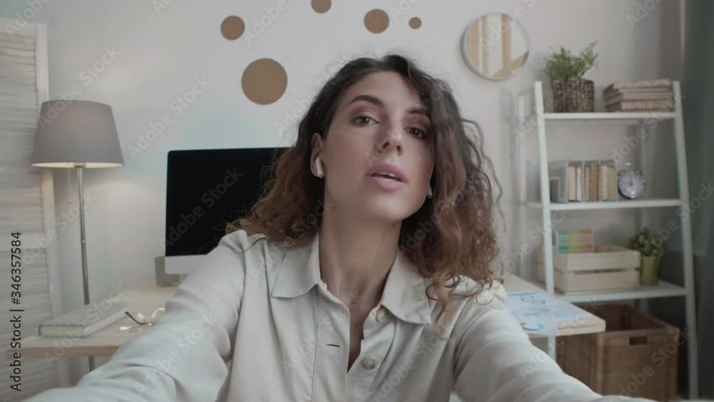 Medium shot portrait of Caucasian woman with curly hair staying home and showing clothes sketches and color palette to client by video link Medium shot portrait of Caucasian woman with curly hair staying home and showing clothes sketches and color palette to client by video link