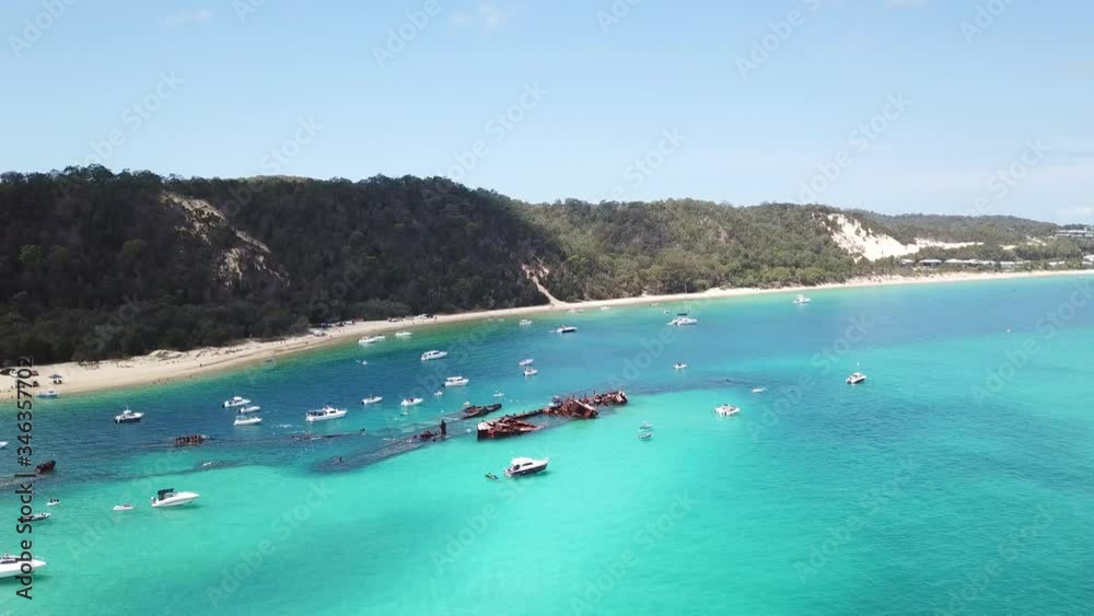 Aerial Drone View Pans Over Crystal Clear Blue Water With Ship Wrecks And Boats Along The Beach Coast Moreton Island. Aerial Drone View Pans Over Crystal Clear Blue Water With Ship Wrecks And Boats Along The Beach Coast Moreton Island.