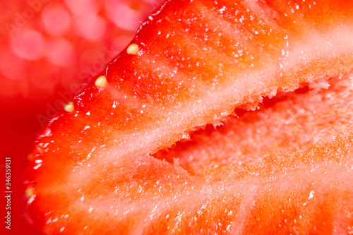 Strawberry background. Blurred natural red background. Texture of strawberry berries. Beautiful sliced strawberries close-up. Horizontal, close-up, nobody. Healthy eating concept.