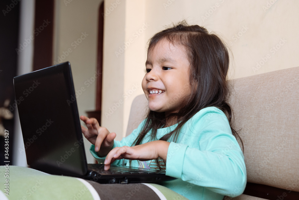 Little girl using a laptop during isolation from the coronavirus outbreak. Closure of schools due to coronavirus pandemic Little girl using a laptop during isolation from the coronavirus outbreak. Closure of schools due to coronavirus pandemic