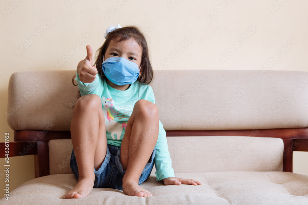 Kid use medical mask or surgical mask to protect her from virus, sickness, Covid-19 and coronavirus infection.