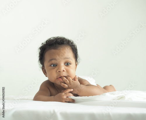 African newborn baby boy lying in bed in the morning.Happy,excited,smile and enjoy emotion.He have beautiful eyes.