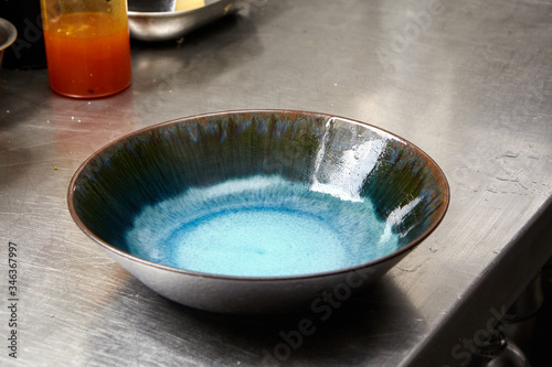 Blue and marine green plate on a kitchen steel table