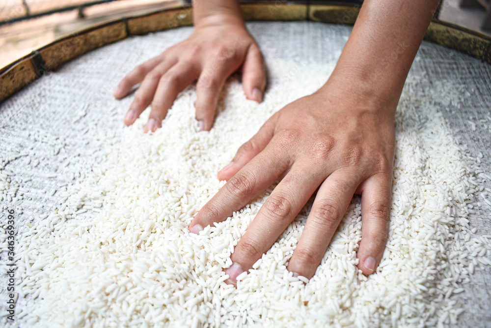 White rice on a wooden background and farmers are drying rice outdoors. 

