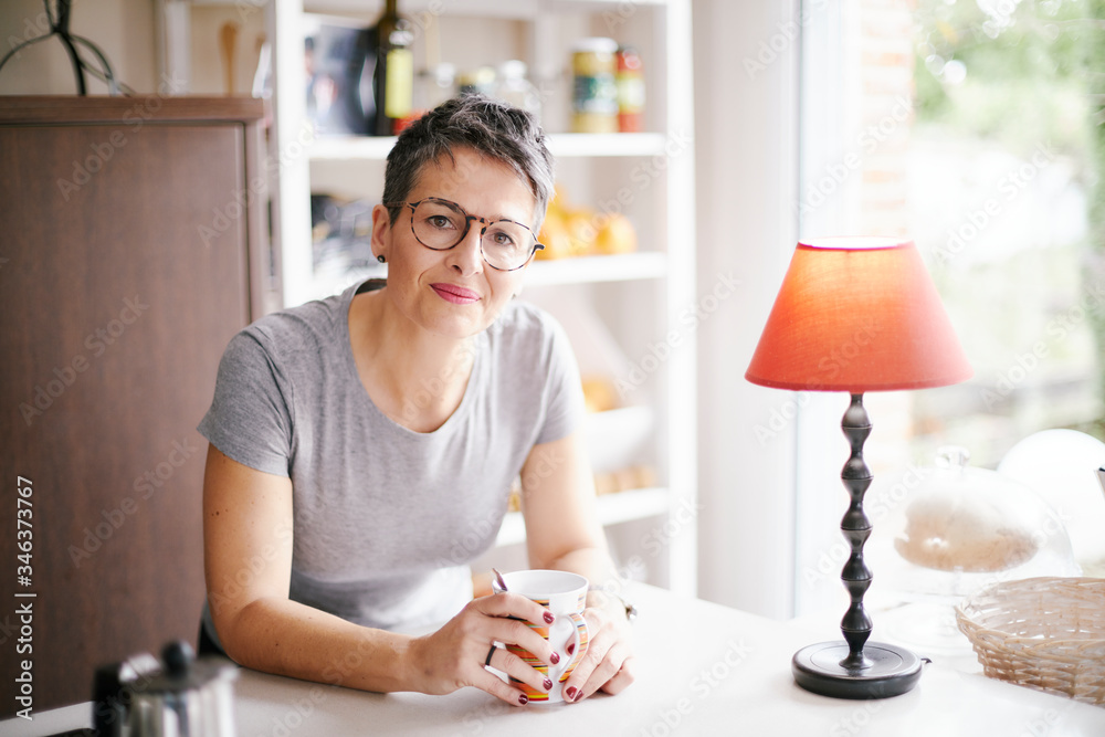 Εκτύπωση καμβά Woman having breakfast in her kitchen, smiling