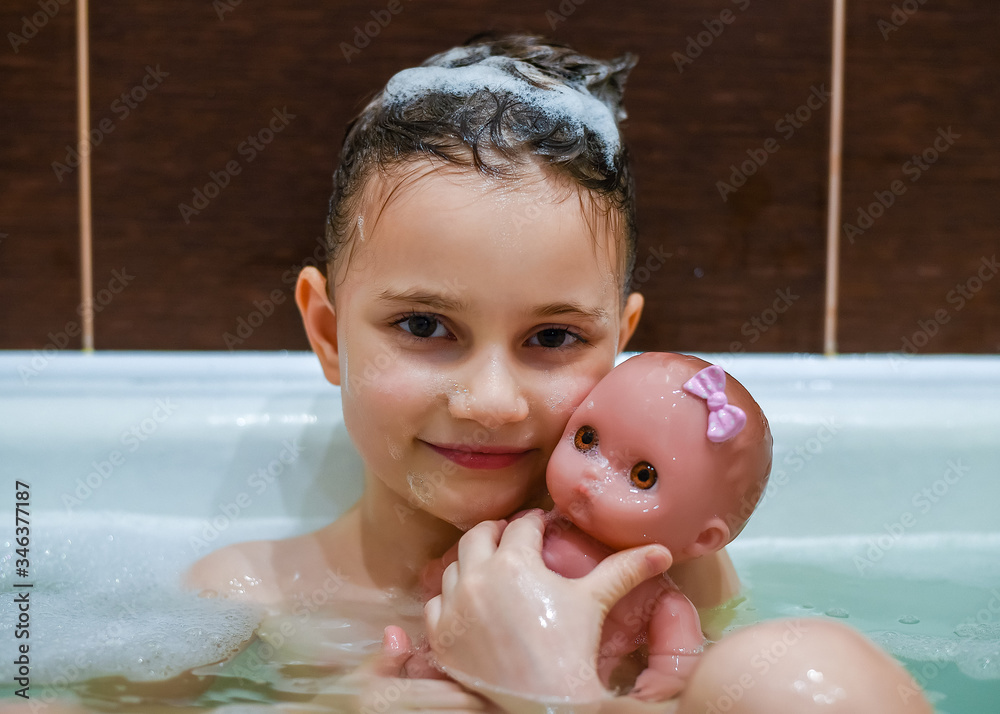 Girl 5 years old in the bathroom with foam. Girl washes her head in the