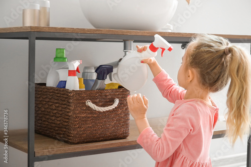 Fotografi Little girl playing with cleaning supplies at home
