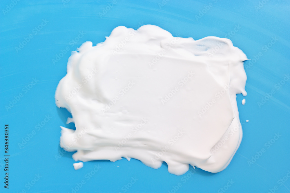 White cosmetic foam blob on blright blue background. Shampoo, cleanser, soap, shaving foam creamy texture. Space for text White cosmetic foam blob on blright blue background. Shampoo, cleanser, soap, shaving foam creamy texture. Space for text