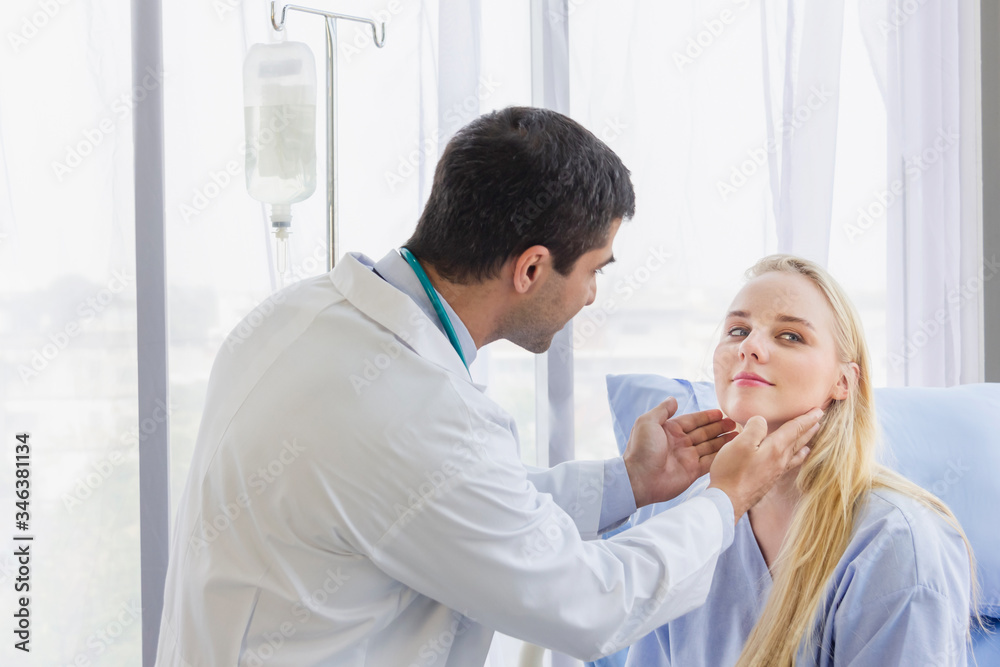 male doctor examined the neck pain of a female patient sitting in hospital bed male doctor examined the neck pain of a female patient sitting in hospital bed