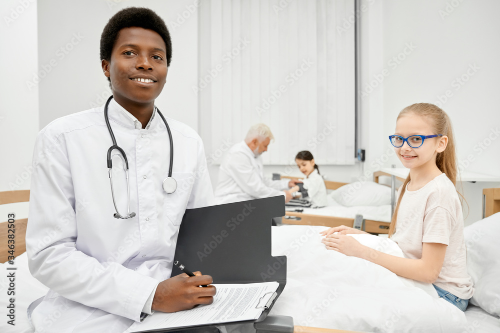 African therapist and schoolgirl on couch in hospital. African therapist and schoolgirl on couch in hospital.