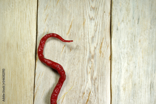 S-shaped curly chili on wooden table. 