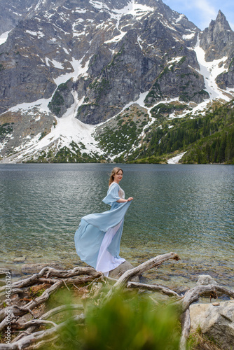 Portrait of a young woman on the background of the Polish lake  Sea Eye  in the Tatra Mountains. Portrait photography in the background of a quiet place without people.