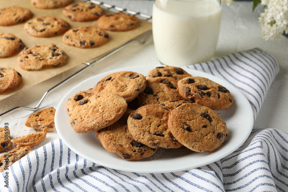 Composition with chip cookies and milk on white table Composition with chip cookies and milk on white table