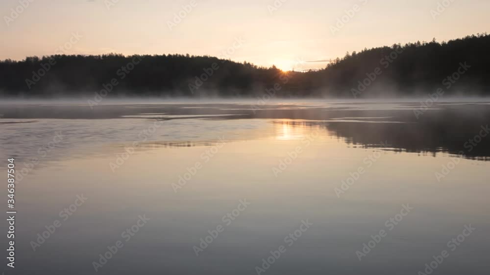 In the Siberian taiga in the early morning at dawn the sun's rays are reflected in the surface of the river In the Siberian taiga in the early morning at dawn the sun's rays are reflected in the surface of the river