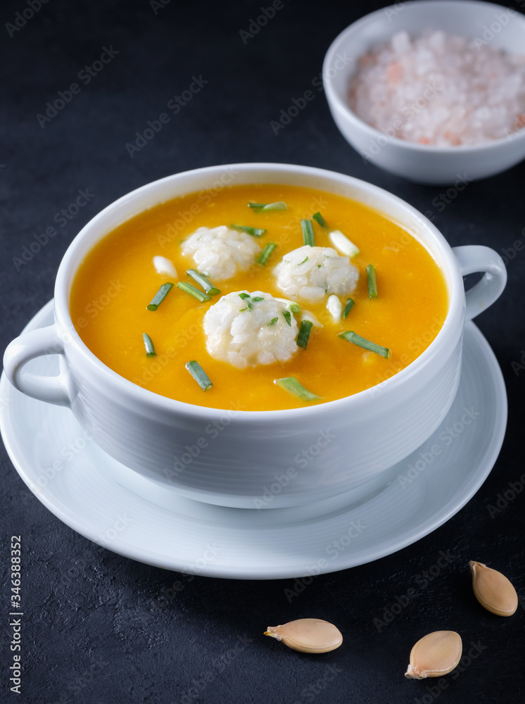Pumpkin cream soup with rice dumplings on a black concrete background with copy space. Healthy eating. Flat lay composition Pumpkin cream soup with rice dumplings on a black concrete background with copy space. Healthy eating. Flat lay composition