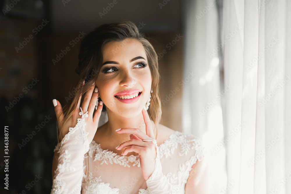 Gorgeous bride in robe posing and preparing for the wedding ceremony face in a room Gorgeous bride in robe posing and preparing for the wedding ceremony face in a room