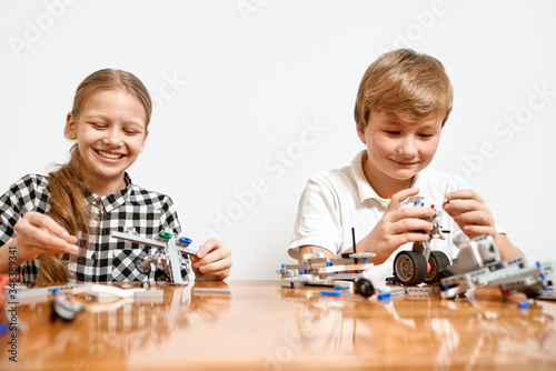 Young friends having fun, using building kit.