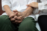 Old elderly patient hands clasped together because of excitement and nervousness,daughter holding touching her arm,care support encourage and empathy senior mother to be more confident at hospital